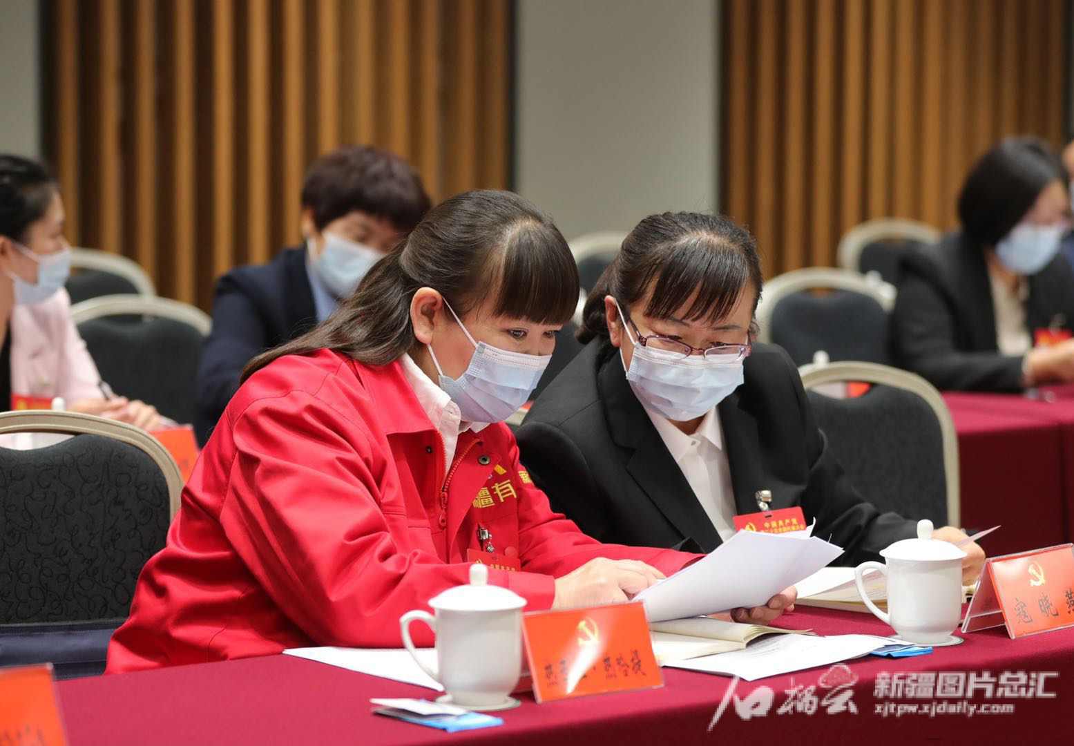 10月17日，出席黨的二十大新疆代表團討論二十大報告。寇曉燕代表（右一）和熱西拉·熱哈提代表在會前交流發(fā)言內(nèi)容。 崔志堅攝 資料圖片