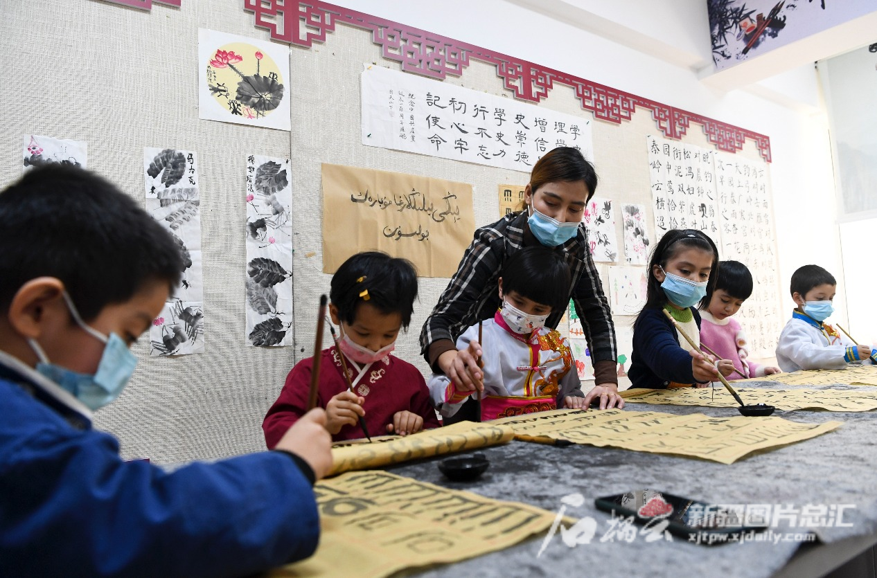 2022年1月14日，小朋友在烏魯木齊市天山區(qū)二道橋街道固原巷社區(qū)開辦的“六點(diǎn)半”課堂學(xué)習(xí)書法。  石榴云/新疆日?qǐng)?bào)記者 湯永攝