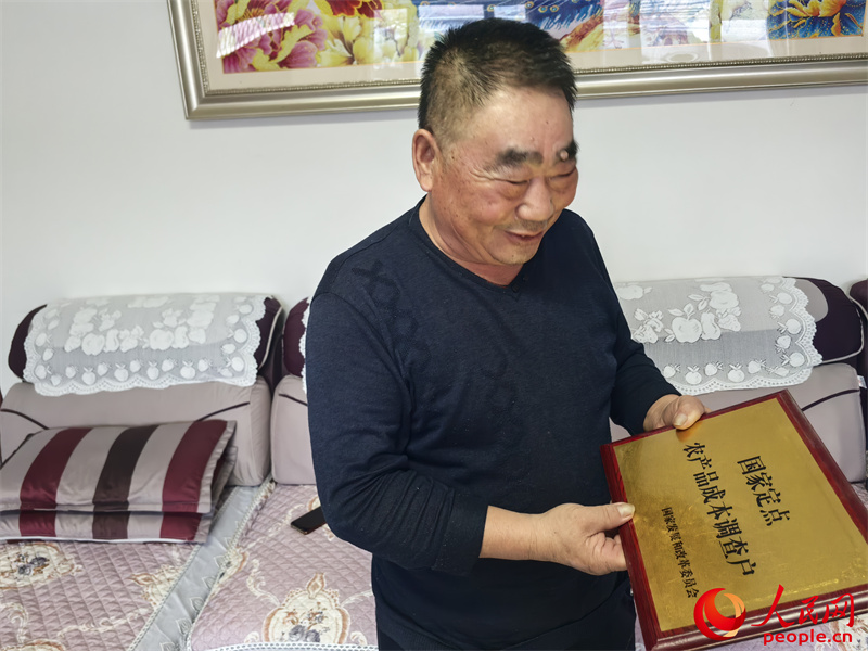 李強(qiáng)向記者展示他獲得的“國(guó)家定點(diǎn)農(nóng)產(chǎn)品成本調(diào)查戶”牌匾。人民網(wǎng)記者 陳新輝攝